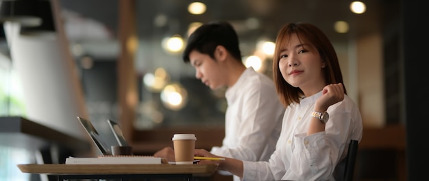 그들의 프로젝트에서 작업하는 동안 공동 작업 공간에 앉아 두 기업인의 자른 샷