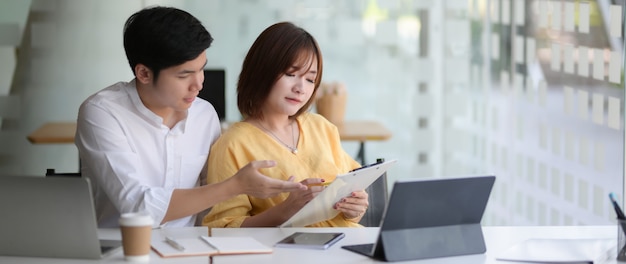 Cropped shot of two businesspeople sitting in glass glass wall office room