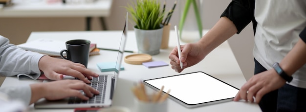 Cropped shot of of two businesswoman working together on white table