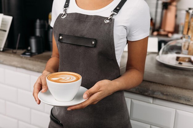 Foto foto ritagliata di un barista irriconoscibile che tiene una tazza di caffè