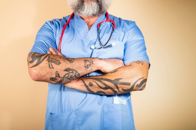 Cropped shot of unrecognizable male nurse standing with arms crossed on light background