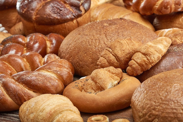 Cropped shot of various bread loafs on the wooden table. 