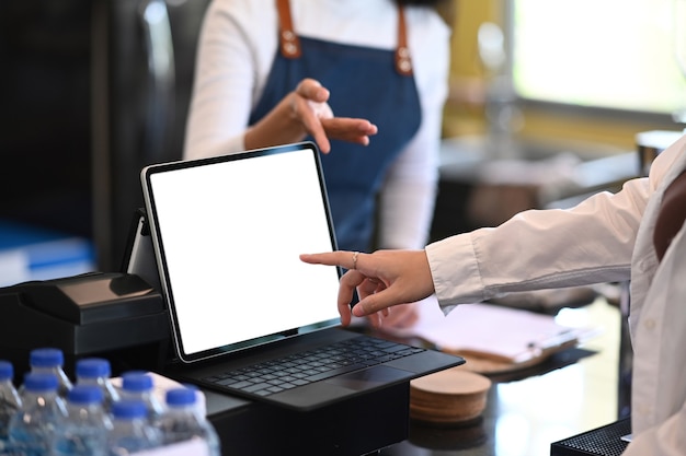 Cropped shot of waiter recommending and accepting orders from customers in modern restaurant or coffee shop.