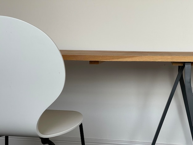 Cropped shot of a white chair near wooden table minimalistic interior design