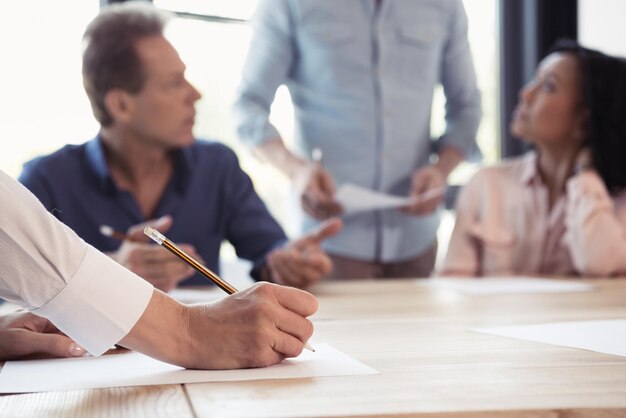 Cropped shot of woman making notes at business meeting in office