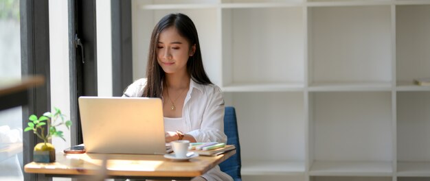 cropped shot of woman university student focusing on her work with laptop