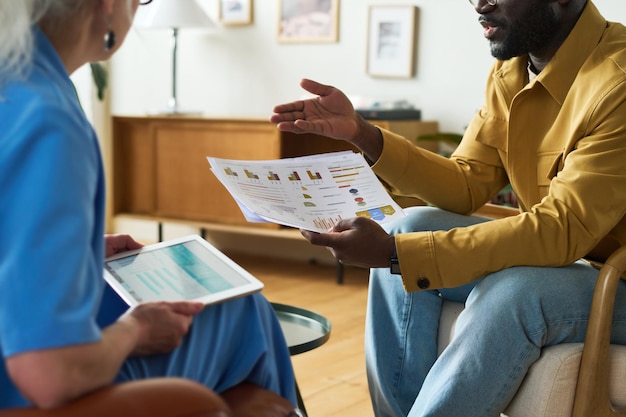 Cropped shot of young black man explaining graphic data to colleague