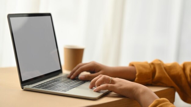 Cropped shot of young female freelancer working with digital tablet on desk at home