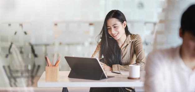 彼女のプロジェクトに取り組んでいる若い女性グラフィックデザイナーのショットをトリミング