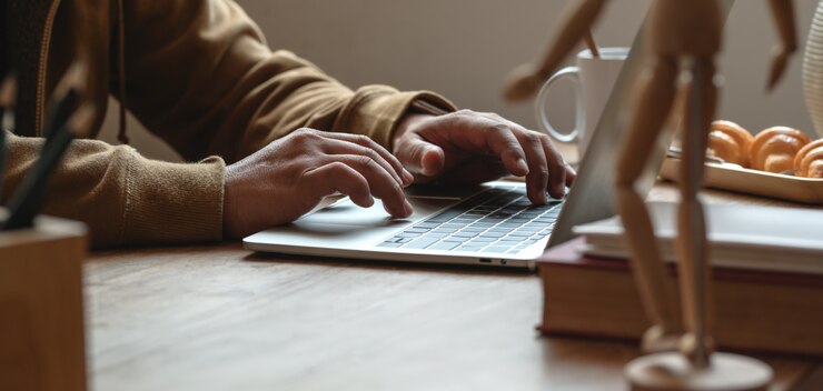 Photo cropped shot of young man typing on laptop computer in comfortable workplace