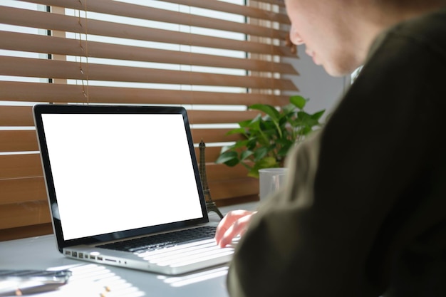 Cropped shot of young man using laptop computer at his home office