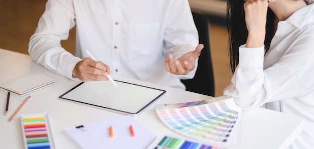 Cropped shot of young professional designer team working on her project while using digital tablet