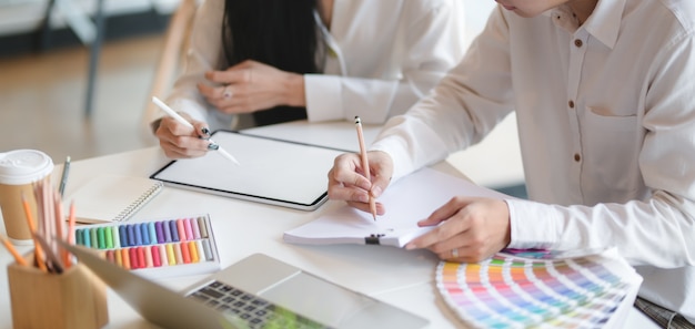 Cropped shot of young professional designer working on their concepts together with mock-up tablet