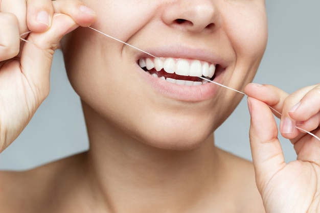 A cropped shot of young woman flossing her teeth oral hygiene\
dental health care morning routine