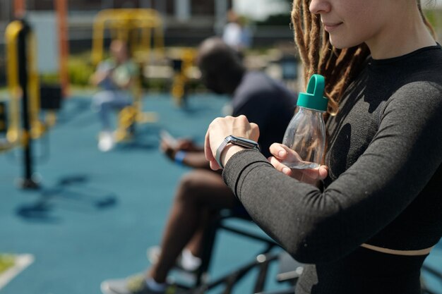 Обрезка молодой женщины в спортивной одежде с бутылкой с водой