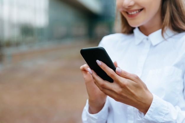 cropped view of businesswoman using smartphone