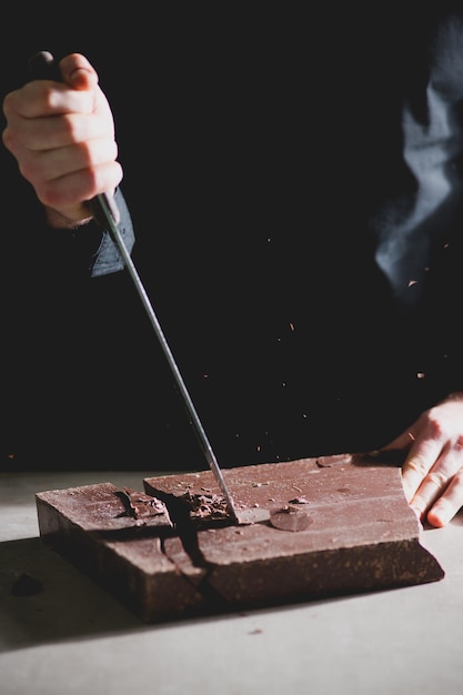 Cropped view of chef cutting chocolate