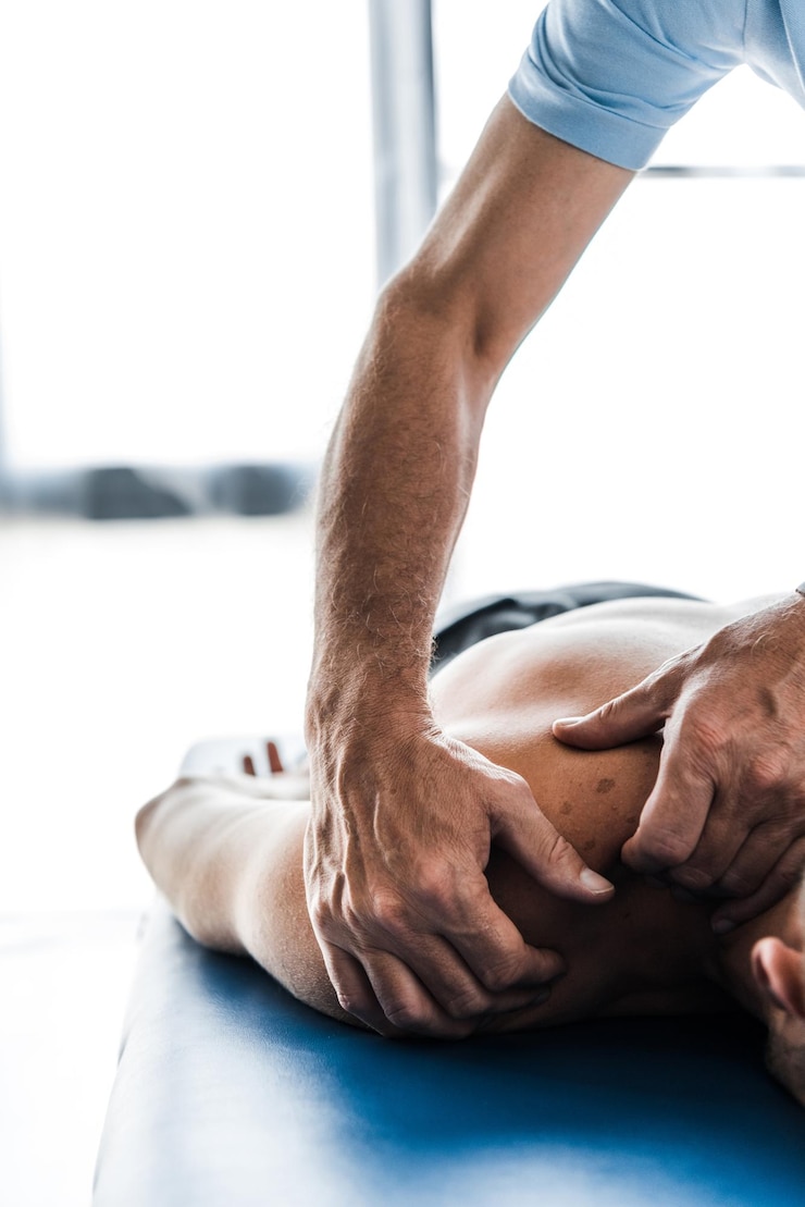 Photo cropped view of chiropractor doing massage to muscular patient