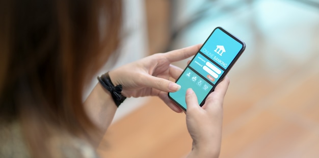 Cropped view of female doing online banking on smartphone 