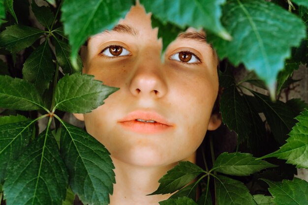 Foto vista ritagliata di ragazza con macchie di età in posa con foglie verdi