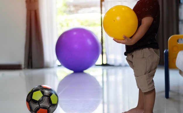 色とりどりのボールを遊んでいる子供のカットされた写真