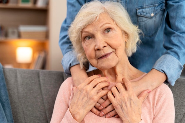 Cropped view of the loving grown up daughter hugging senior mother from back Happy mature grandmother posing for family photo at home