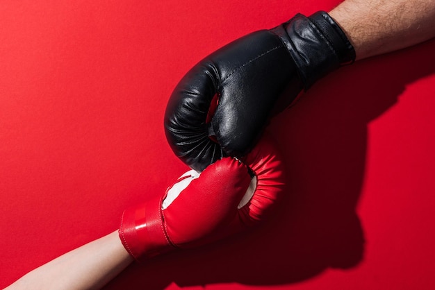 Cropped view of man and woman in boxing gloves on red