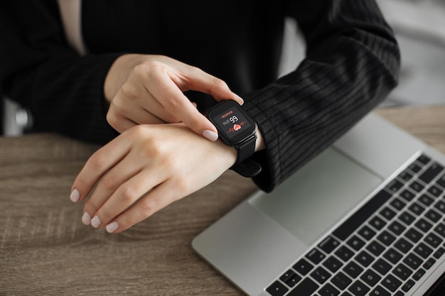 Cropped view of muslim female hands putting finger on smartwatch measuring heartbeat rate