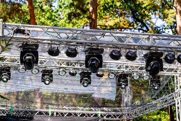 Cropped view of the part of metal structures with lights at
height for the event. preparation and concert outdoor concept