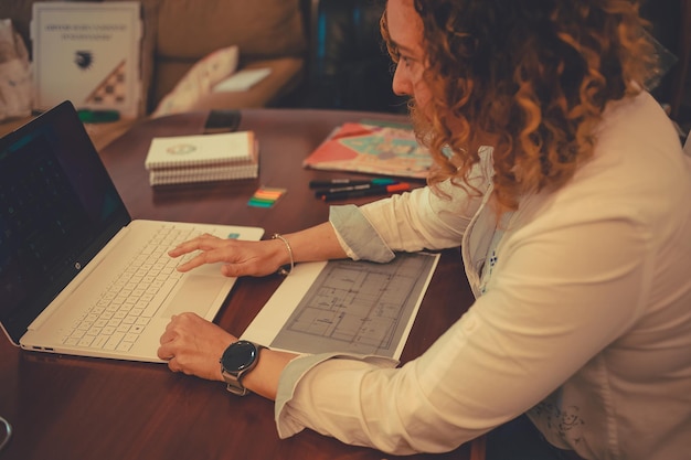 Photo cropped view of a small business owner woman taking notes on paper notebook.