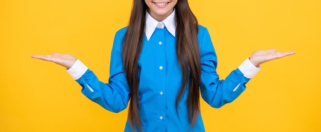 유니폼을 입은 십대 학교 소녀의 배경 사진에 스튜디오에서 십대 학생 소녀의 절단된 시선 십대 고등학교 소녀는 노란색에 고립되어 있습니다.