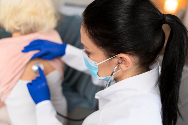 Cropped view of the therapist doctor measure heart rate by stethoscope on older patient Young woman nurse taking care of senior elderly woman at home Medical insurance service concept