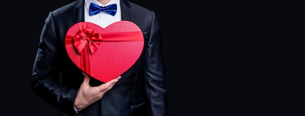 Cropped view of tuxedo man with proposal valentine gift photo\
of tuxedo man hold proposal gift