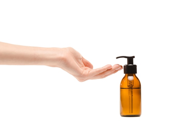 cropped view of woman with cupped hand near dispenser bottle with isolated on white