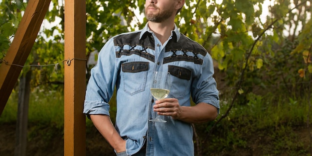 Cropped vinedresser man hold wineglass at vineyard outdoor grape farm