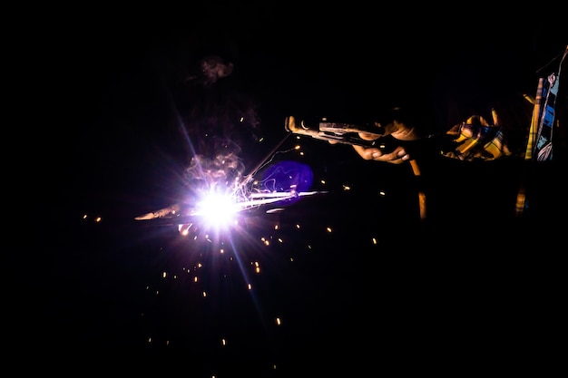 Photo cropped welder welding metal in factory