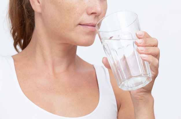 Cropped woman holding glass of pure water going to drink