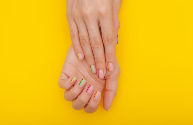 Cropped woman showing nail art on colored background