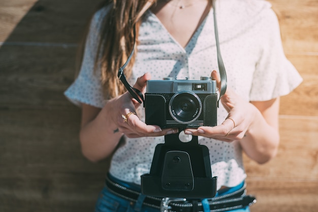 Cropped woman with vintage old camera