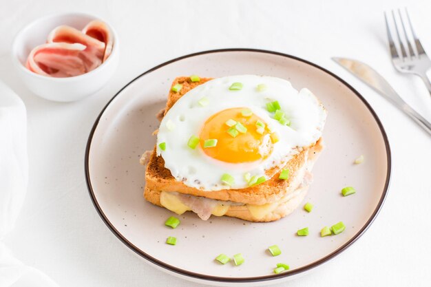 Croque madam sandwich met kaas ham en ei op een bord op een lichte tafel Stevig huisgemaakt ontbijt