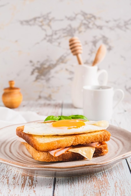 Croque madame boterham met ham, kaas en ei op een bord op de tafel verticaal