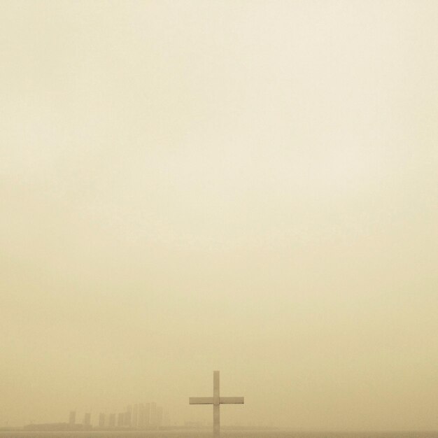 Cross against clear sky during foggy weather