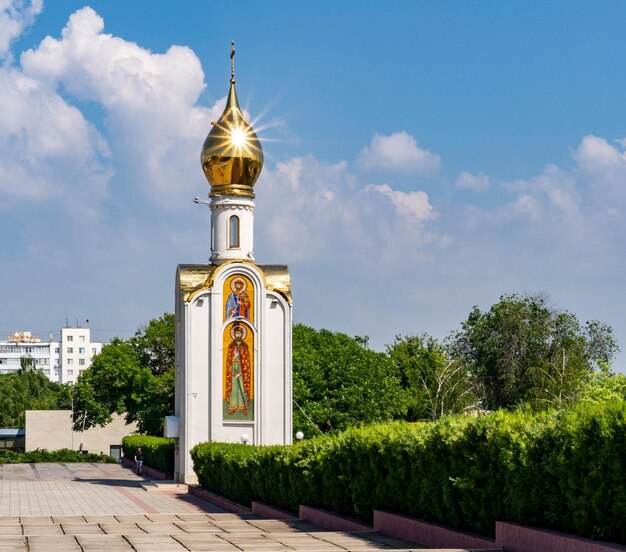 Крест среди деревьев и зданий на фоне неба