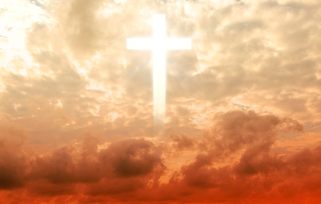 Photo the cross of christ in the yellow sky, the cross on a huge cloud, with the rising sun behind. epic cloud,