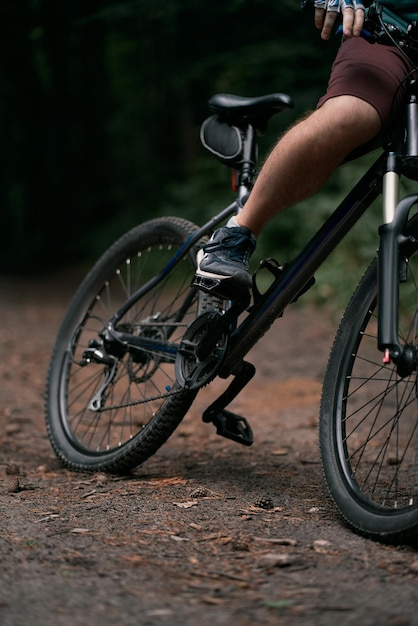 Cross country cycling in the woods Close up of mountain bike and rider's legs Extreme braking on the forest trails