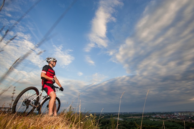 Cross country fietser rust op de top van de heuvel