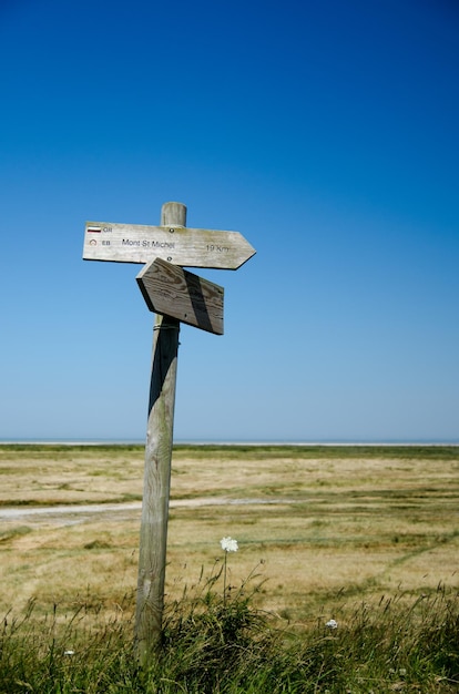 Cross on field against clear blue sky