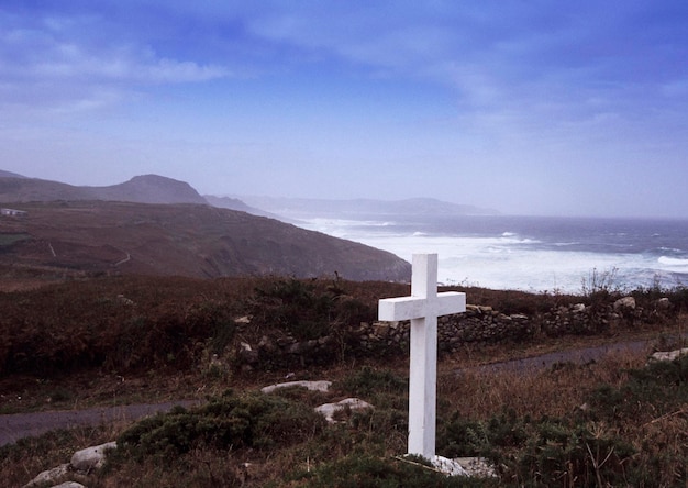 Cross on field against sea