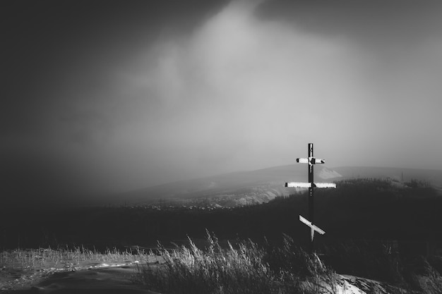 Cross on field against sky during winter