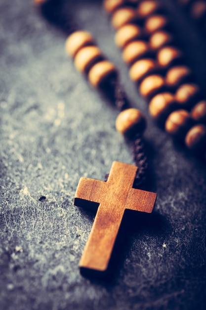Cross and rosary on stone background